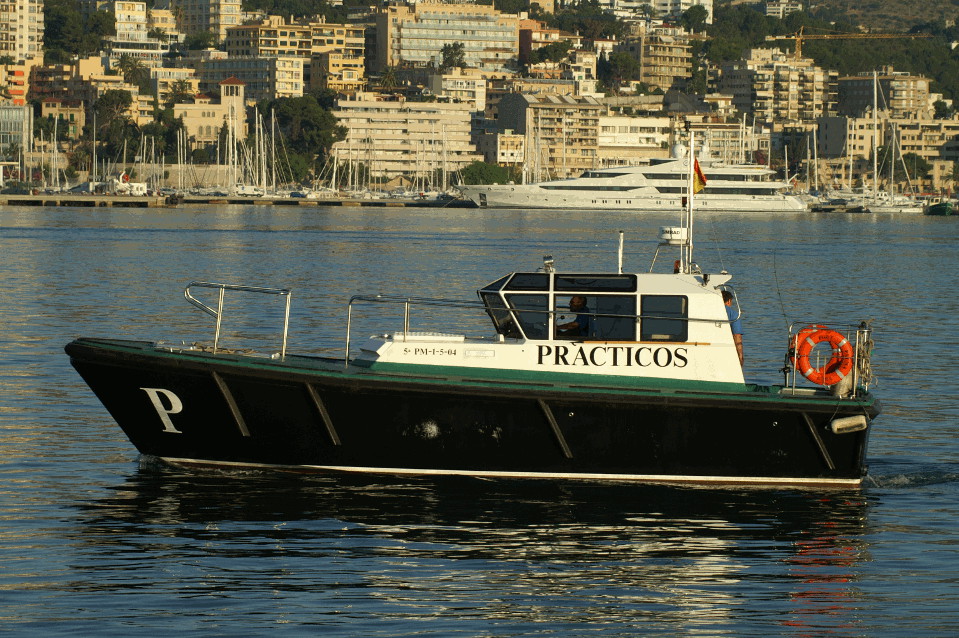 Buque de servicio práctico de puerto verde, negro y blanco realizando maniobra en el Puerto de Palma de Mallorca.